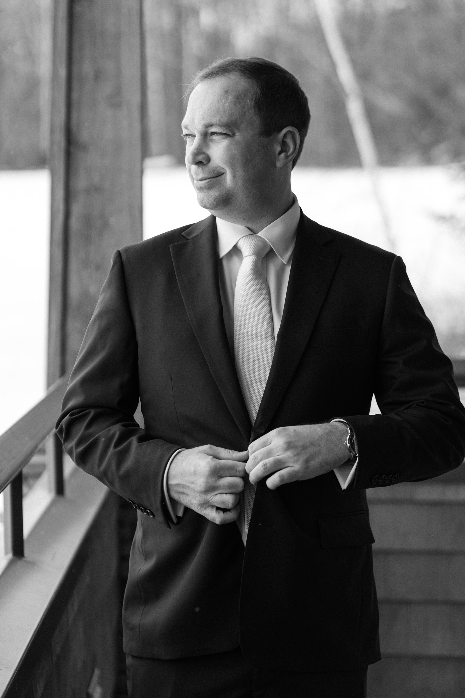 groom buttoning coat during Vermont Wedding at The Jewel at Mountain Top Inn