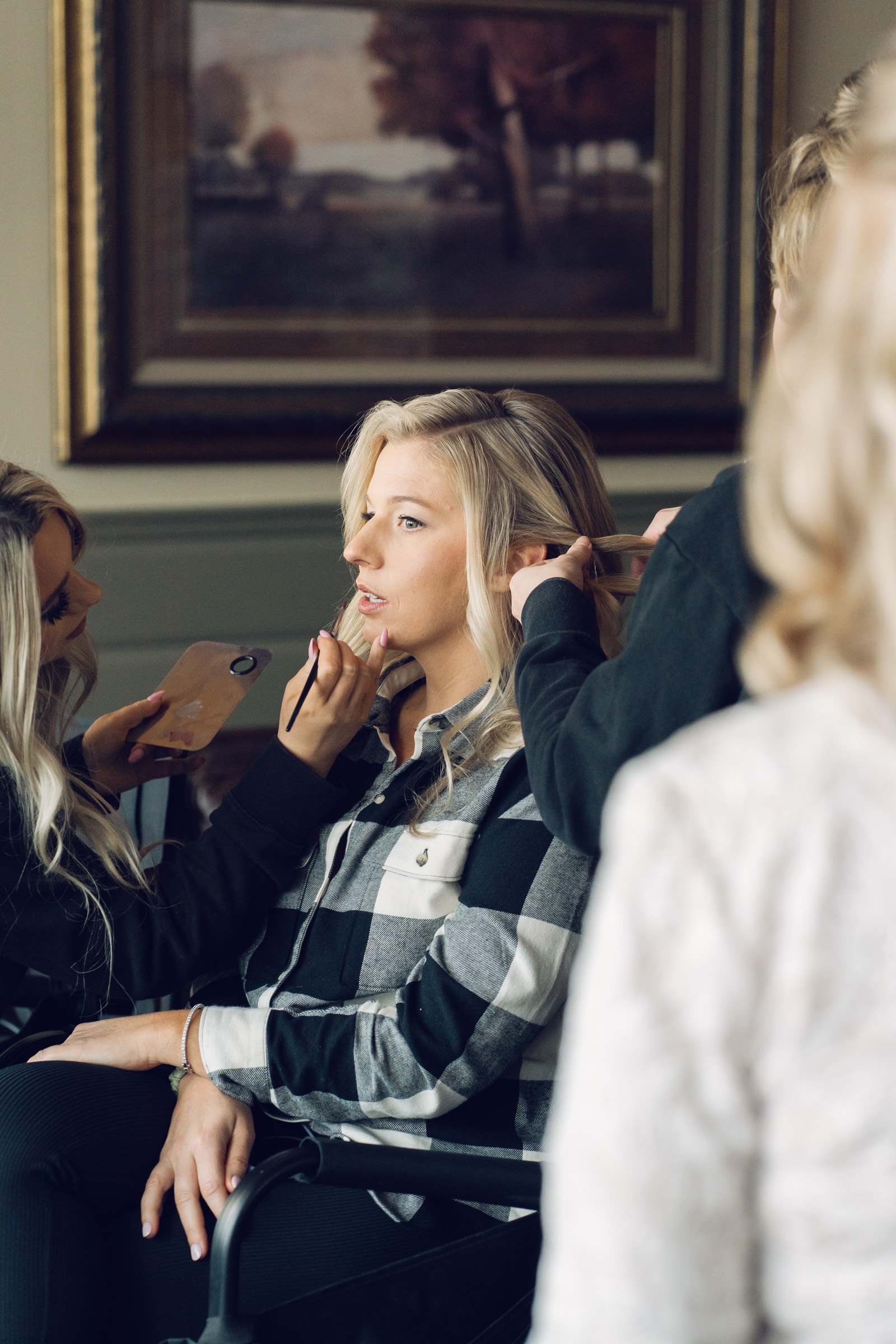 bride getting hair done wearing flannel shirt during Vermont Wedding at The Jewel at Mountain Top Inn