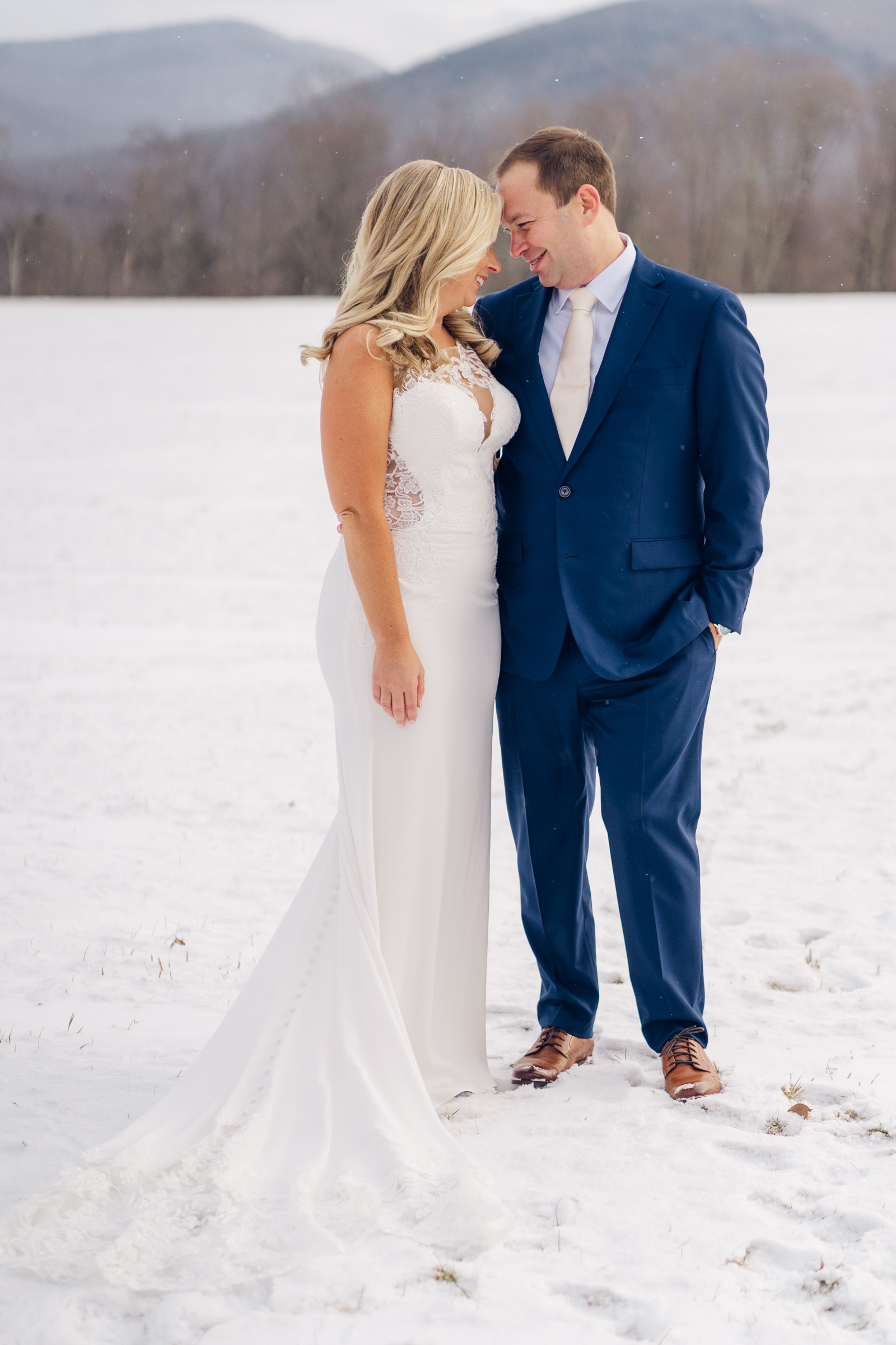 couple snuggle during winter wedding at mountain top resort