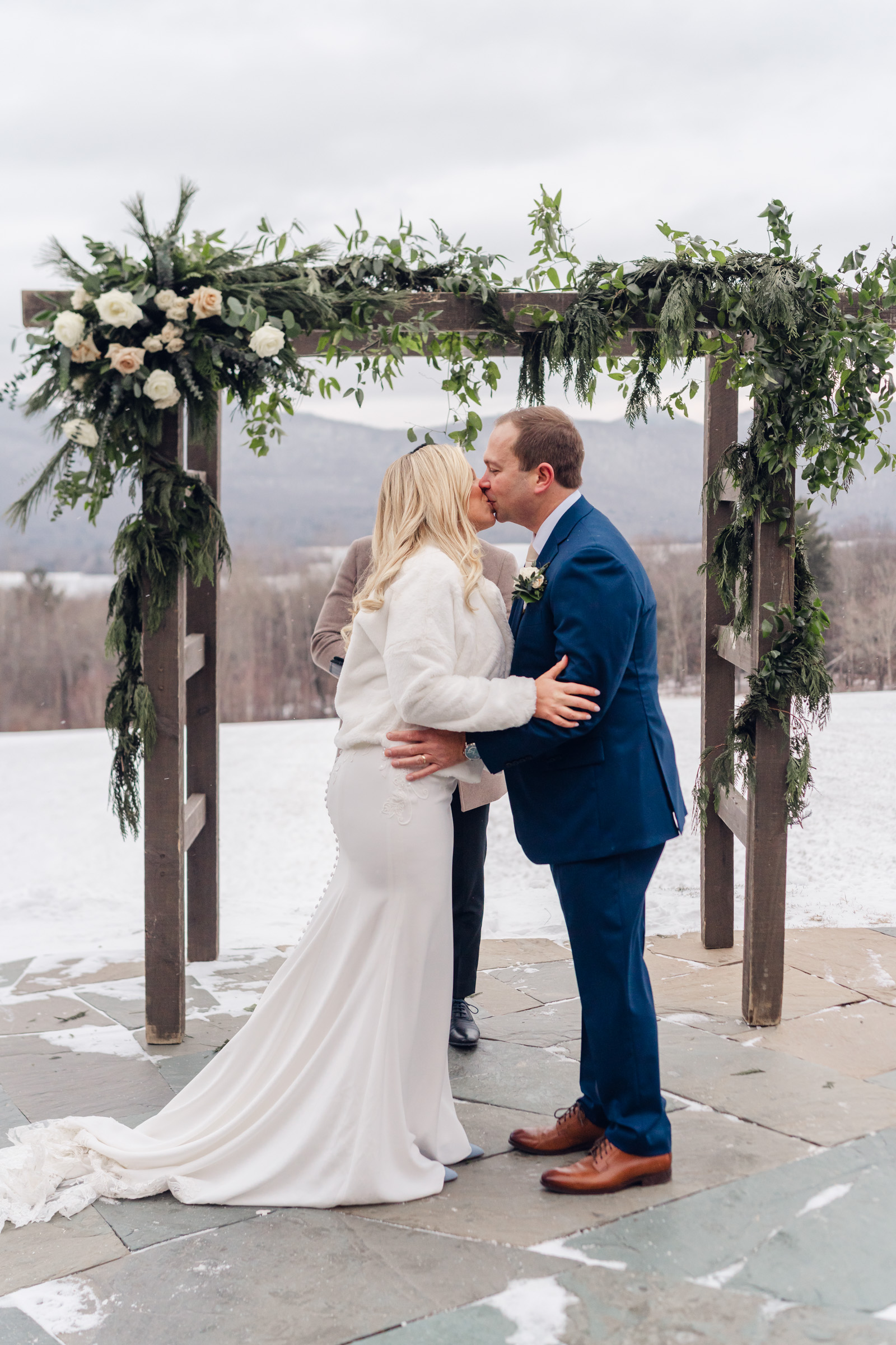 couple share first kiss during outdoor wedding at mountain top resort