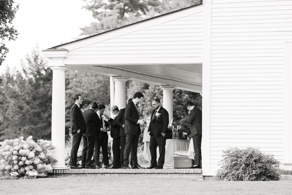 groomsmen hanging out on porch at the fells in newbury nh