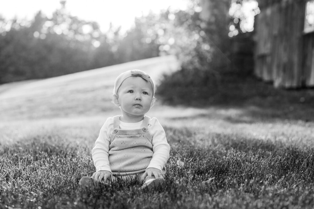 toddler sitting in sunlit grass during upper valley fall family photo session