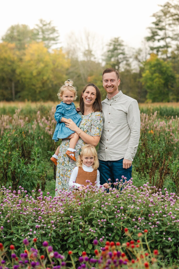 parents and daughters standing in flower field at riverview during upper valley fall family photo session
