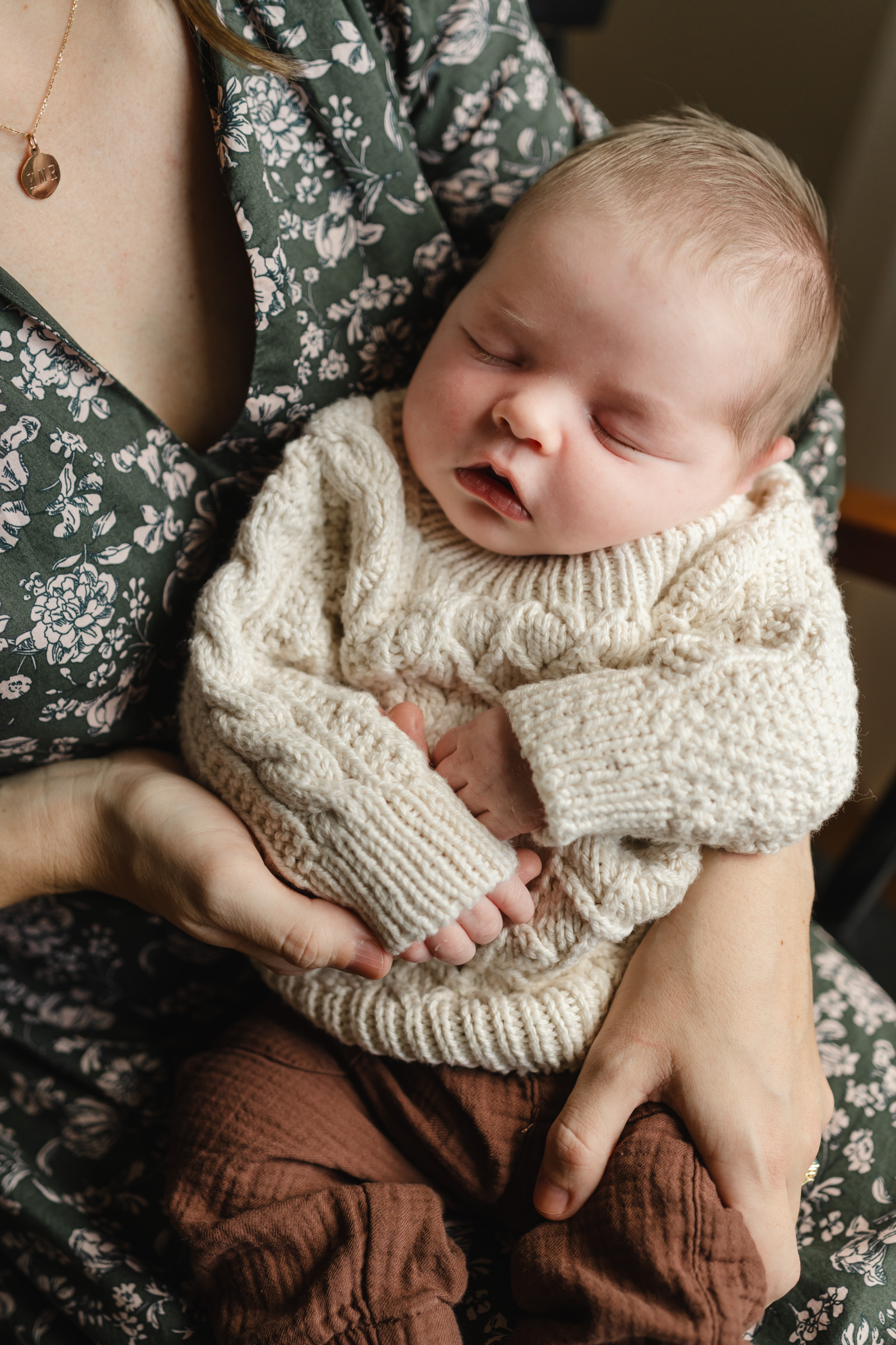 sweet baby in sweater nestled in mothers lap, upper valley newborn photographer, nh vt