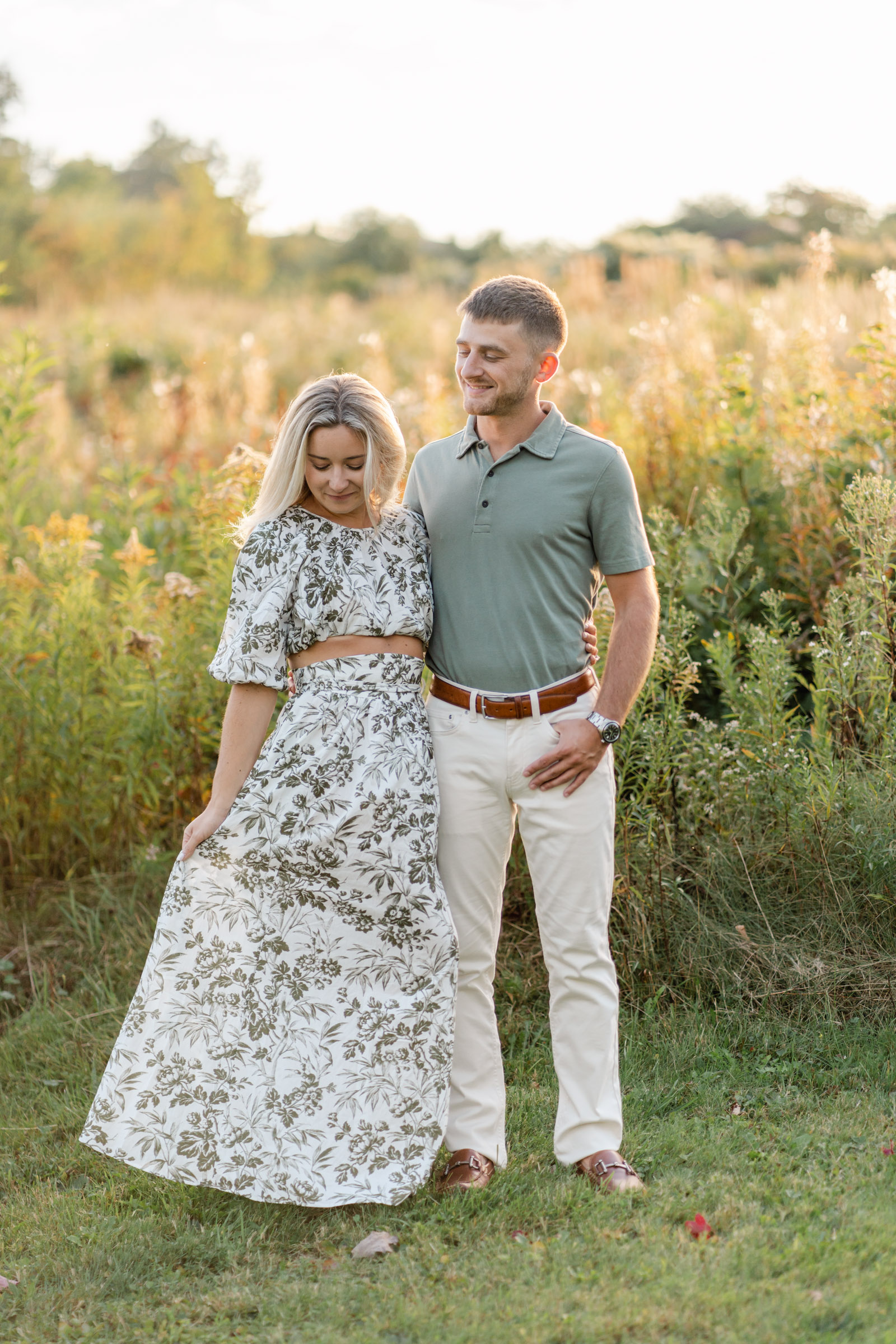 couple standing in front of backlit grass Sugar Hill white mountains engagement session