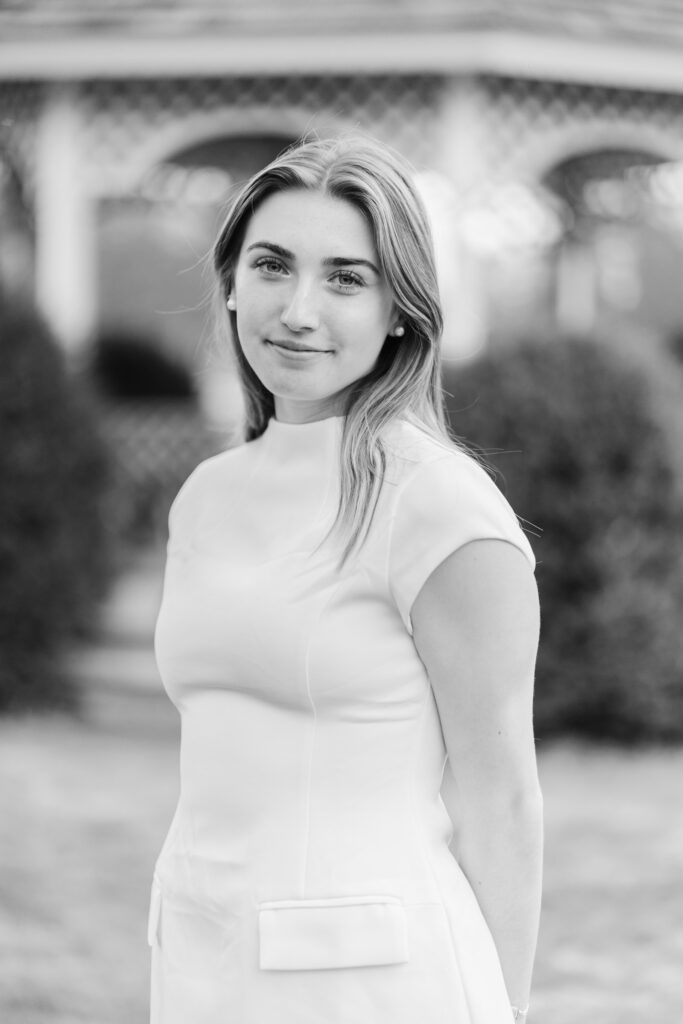 close up side angle portrait of female graduate in white dress