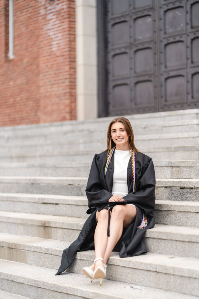 female grad sitting on steps of armory during norwich university photo session