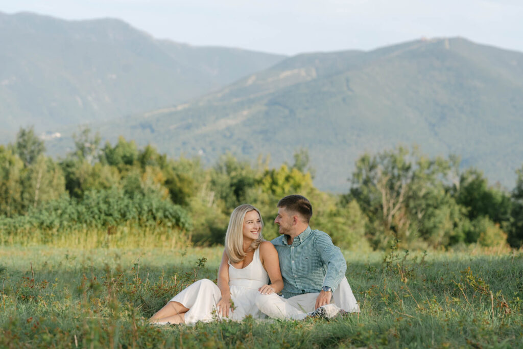 wide view of couple sitting on blanket sugar hill white mountain engagement session