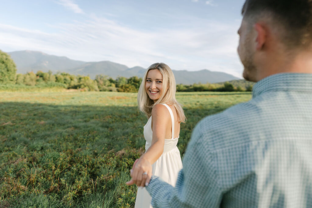 woman leading man toward mountains during white mountains eng session