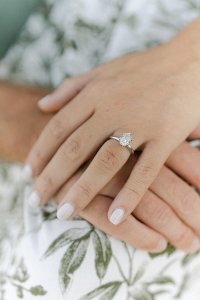 close up of engagement ring and hands together