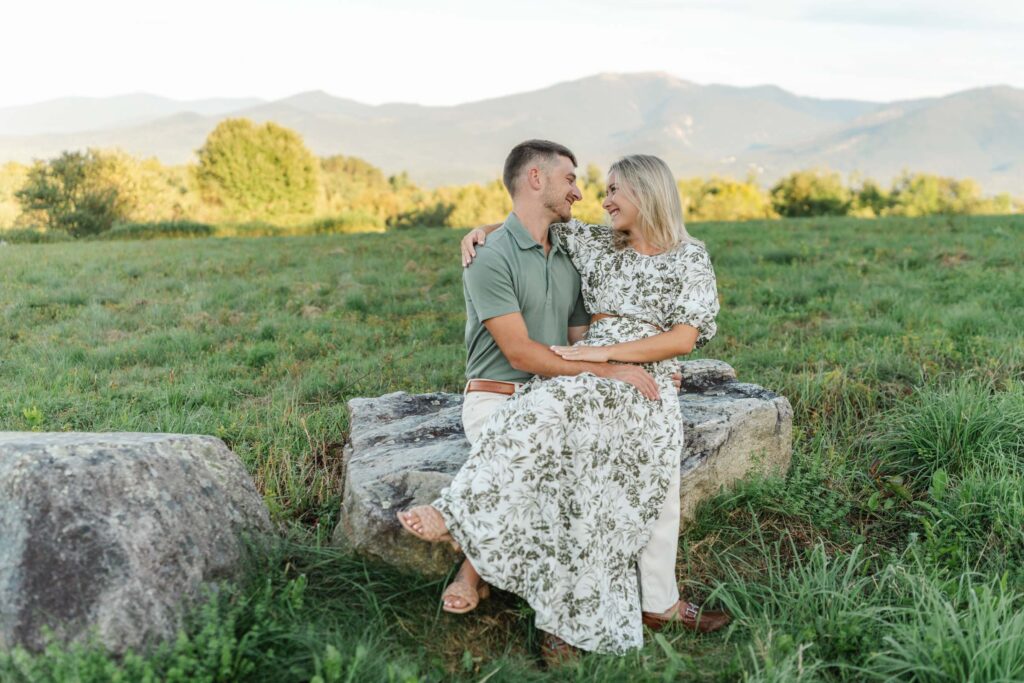 couple sitting on rock on lupine field sugar hill white mountain engagement session