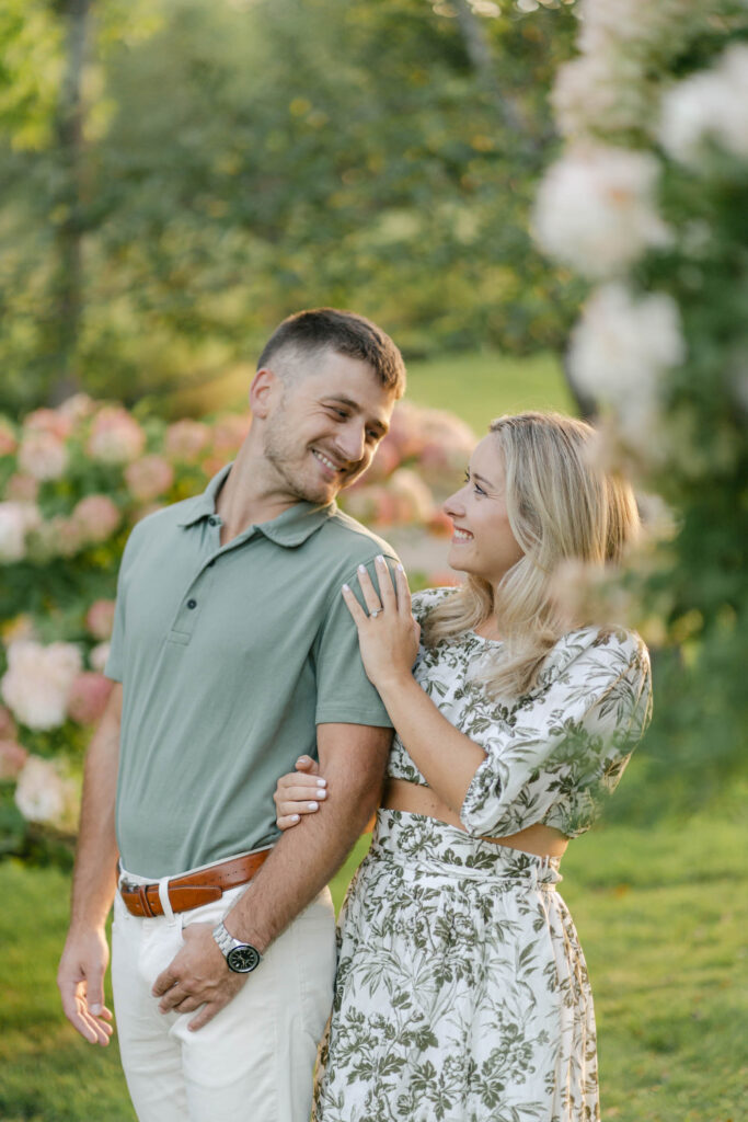 couple stand looking at each other with hydrangeas sugar hill white mountain engagement session