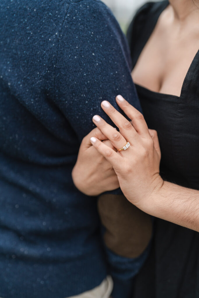 woman holding onto man's arm showing engagement ring during woodstock vermont engagement session
