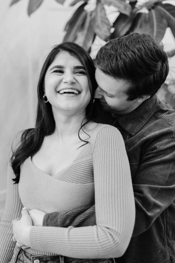 woman laughing as man snuggles into her neck during woodstock vermont engagement session