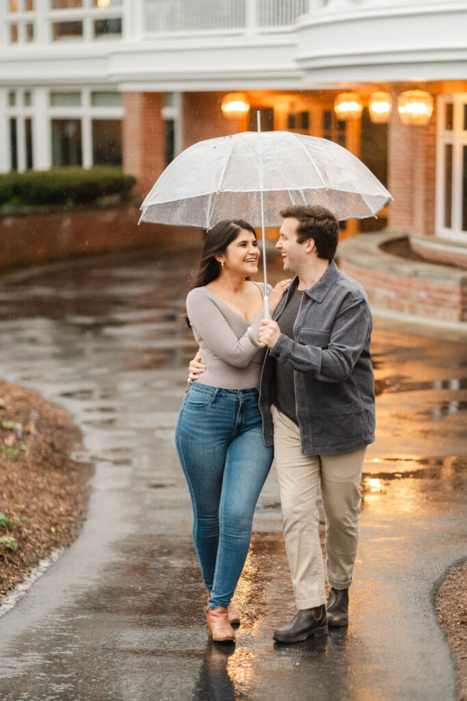 couple holding onto each other walking away from backside of woodstock inn during woodstock vermont engagement session