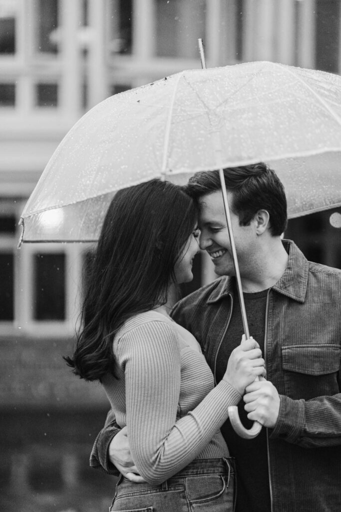 couple forehead to forehead under umbrella during woodstock vermont engagement session