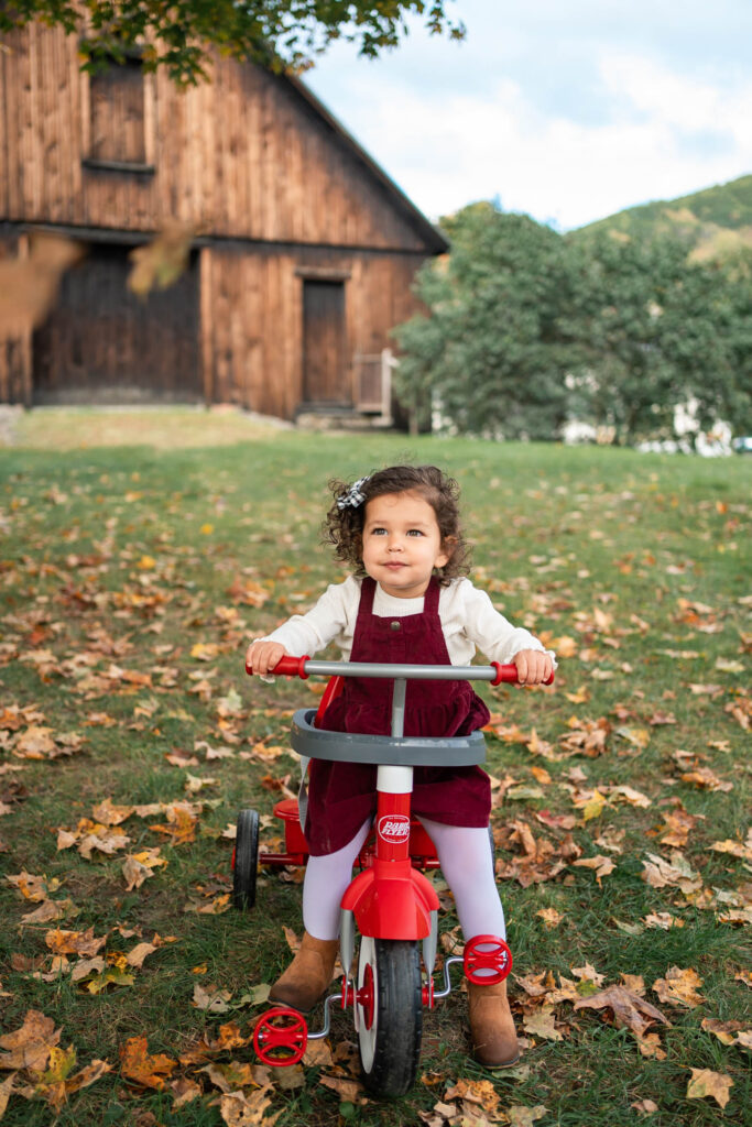 October Family Photos in Woodstock Vermont, young girl on tricycle