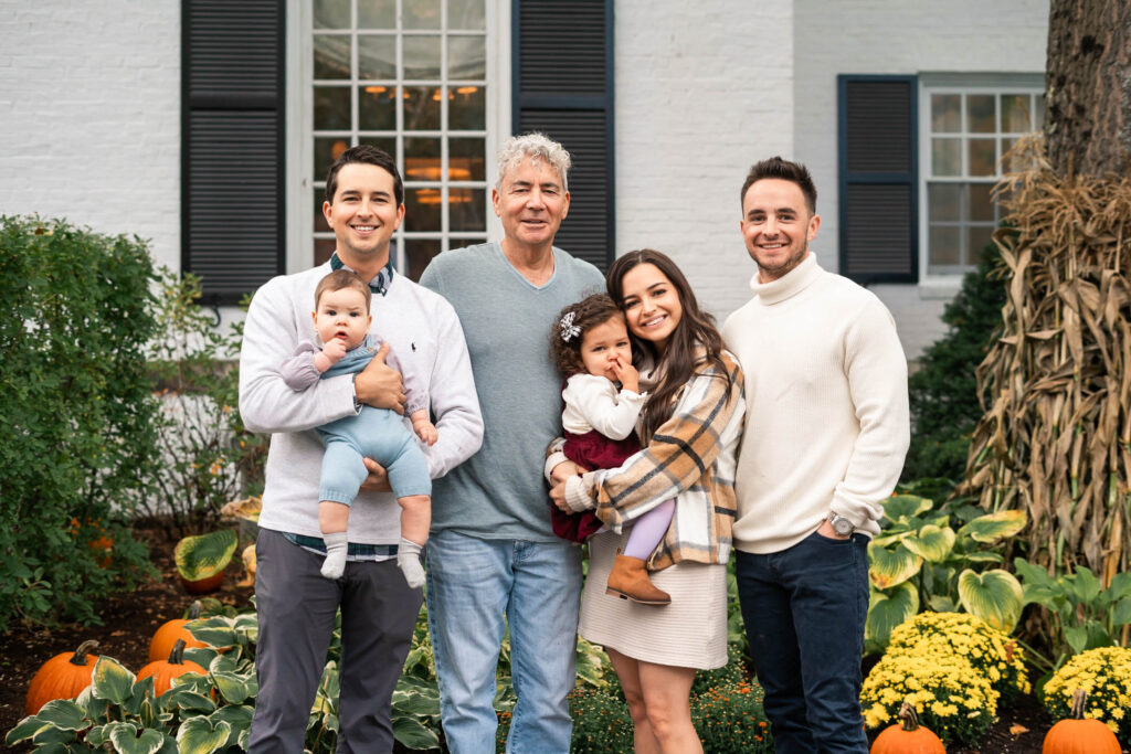 Multiple generations of family standing in front of Woodstock Inn, posing for picture