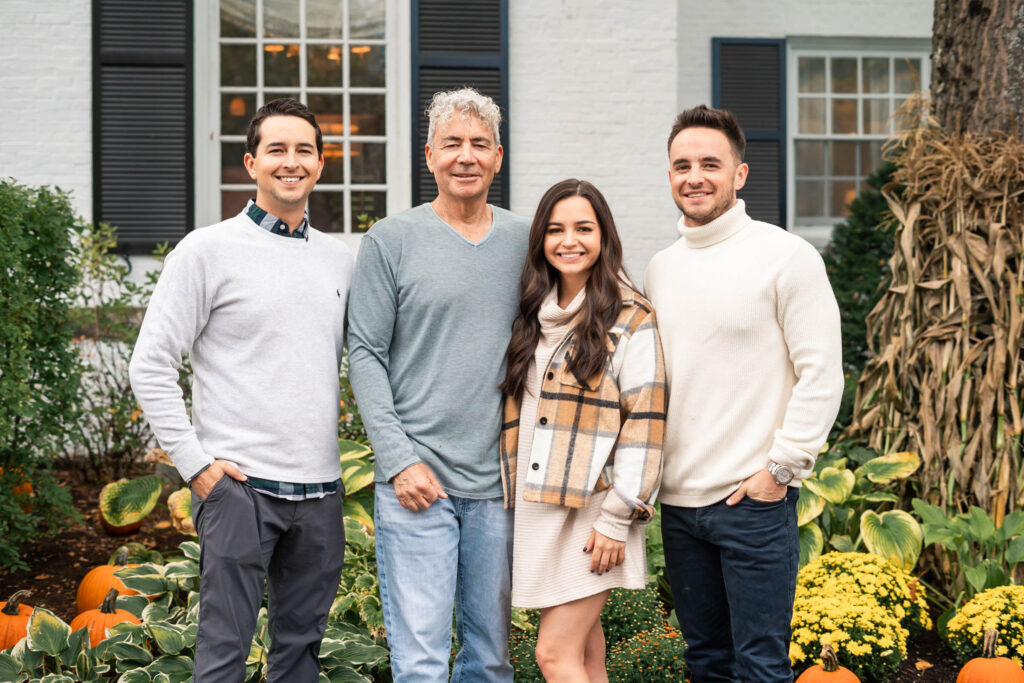 Father and siblings family standing in front of Woodstock Inn, posing for picture