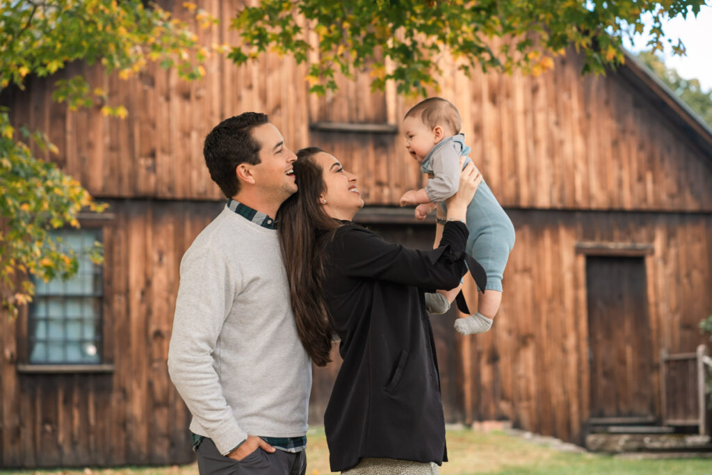 Parents lifting baby up during woodstock vermont fall family photo session