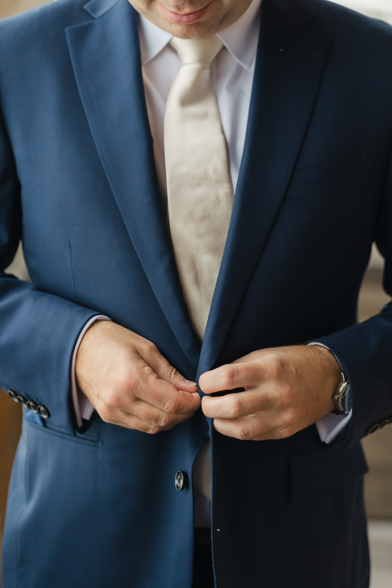 groom buttoning jacket