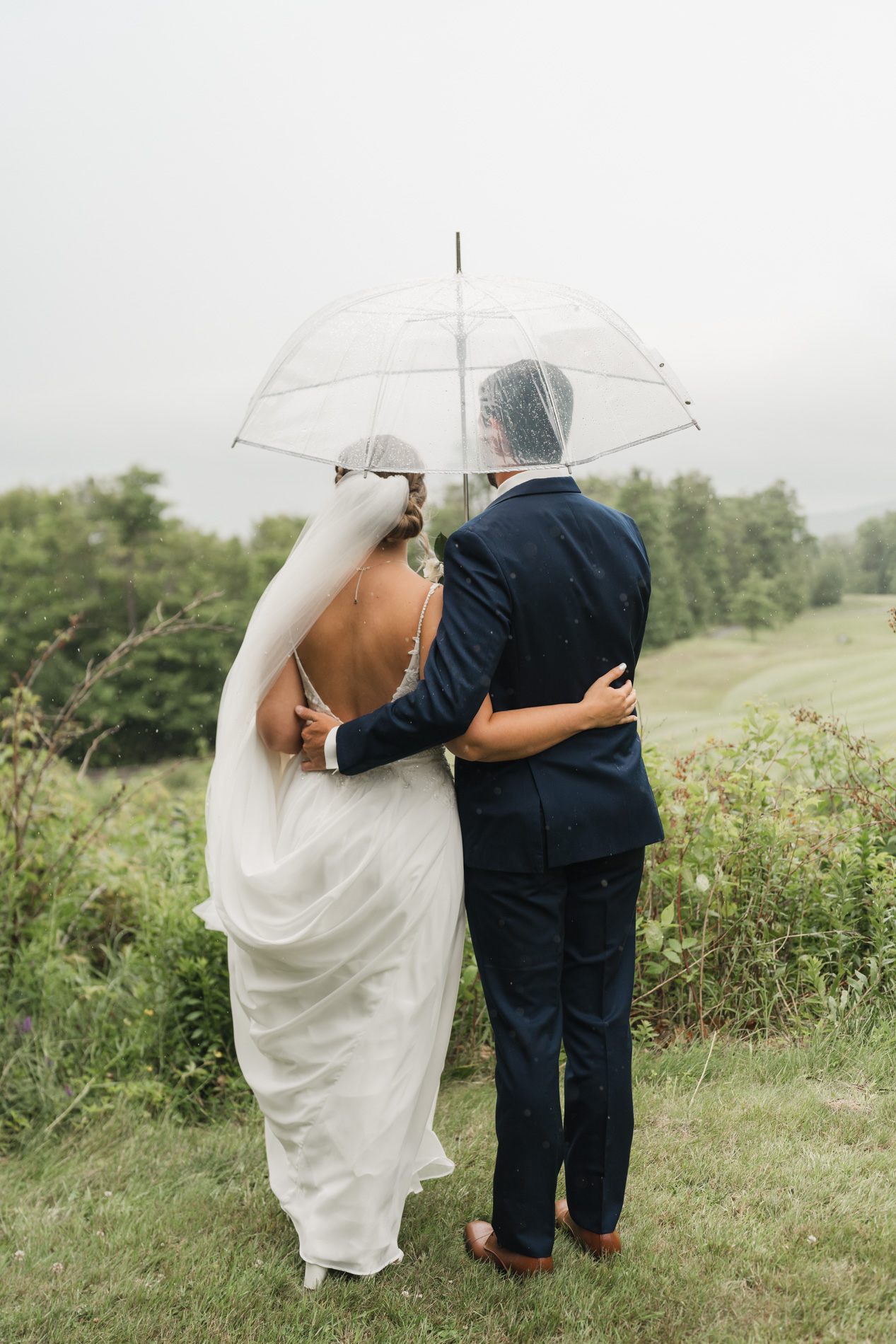 vermont wedding photographer - couple under umbrella looking out at view