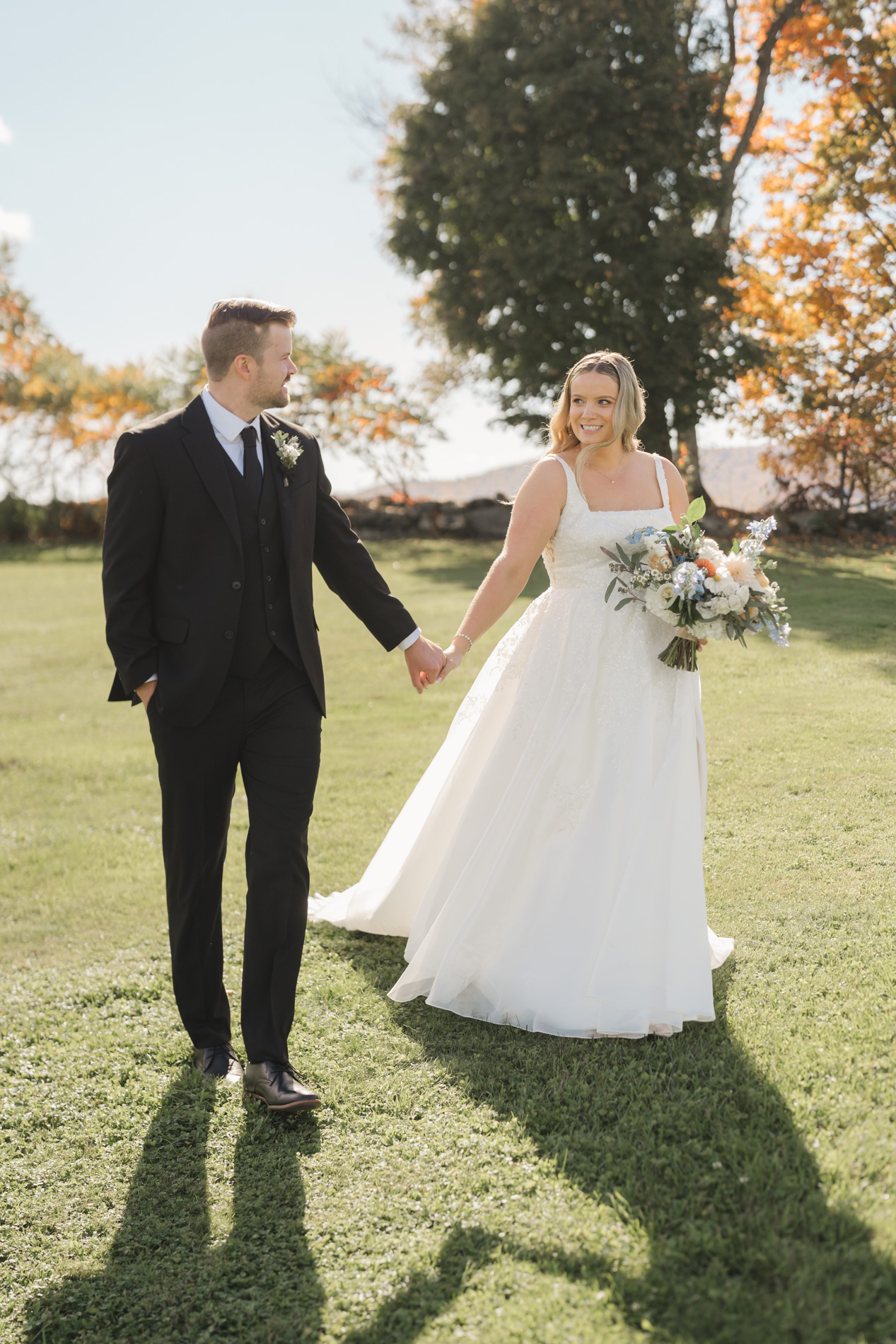 bride and groom walking across lawn