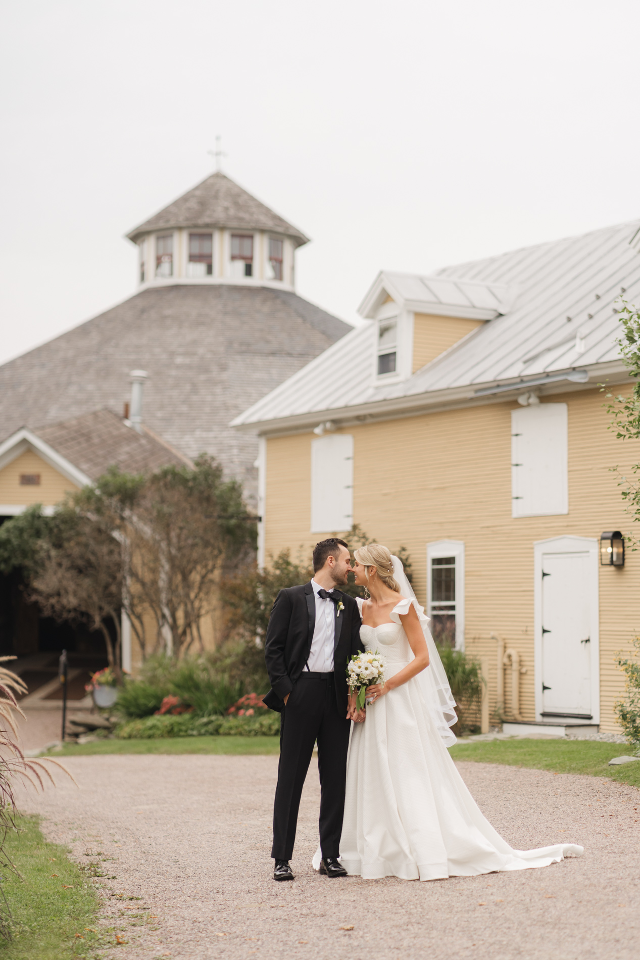 New England Wedding Photographer - Courtney Cania captures Inn at round barn farm wedding - couple walking in front of barn
