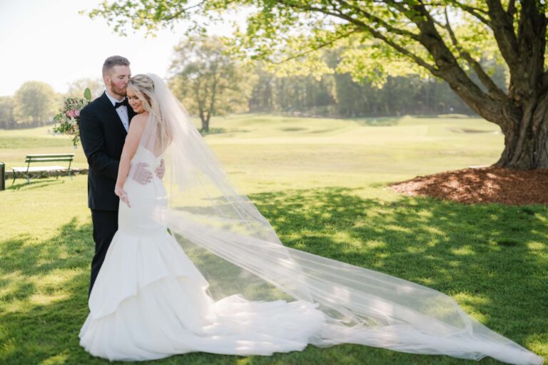 Couple posing on a golf course at oak hill country club wedding
