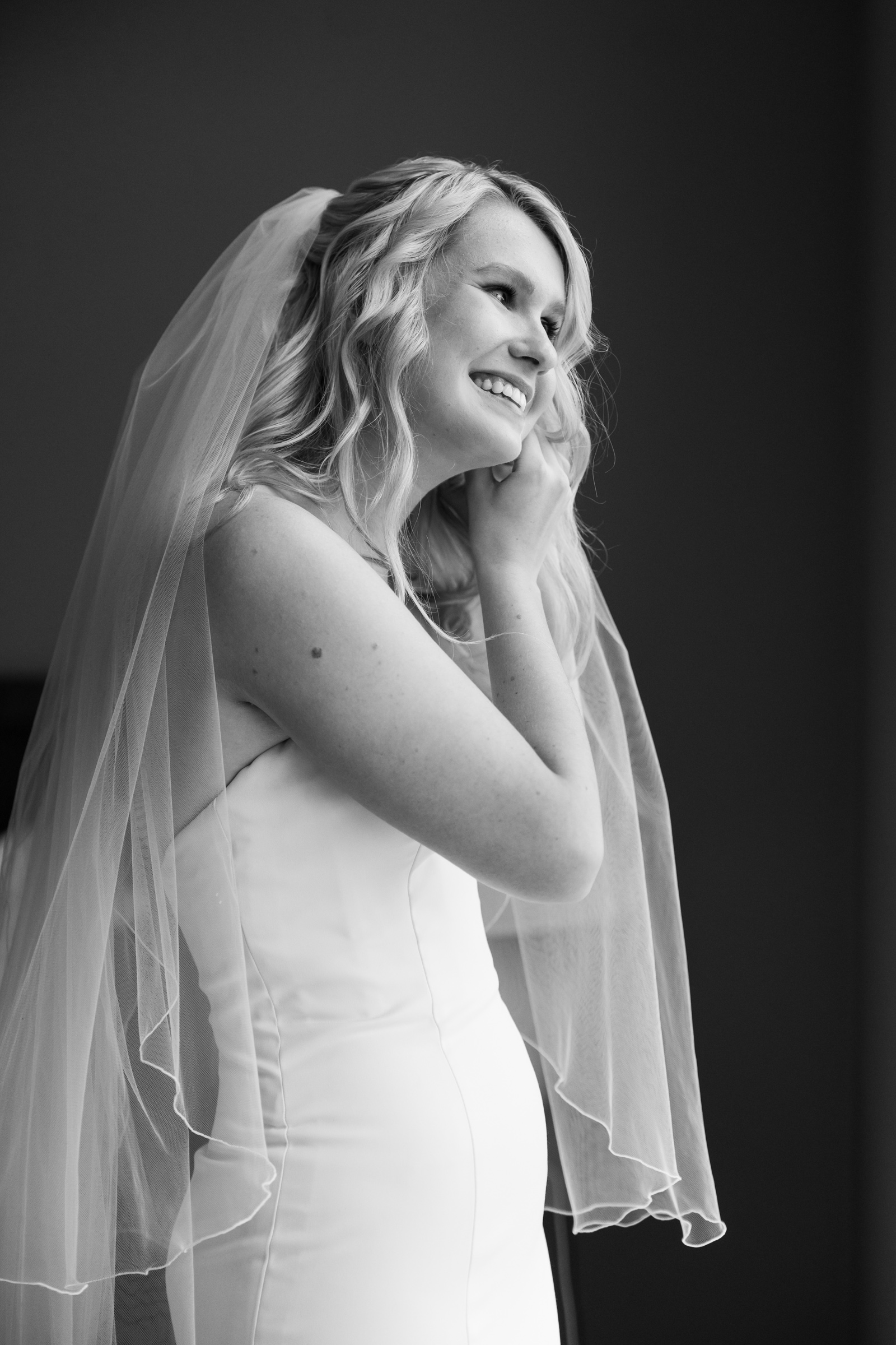 bride putting on earrings - massachusetts country club wedding