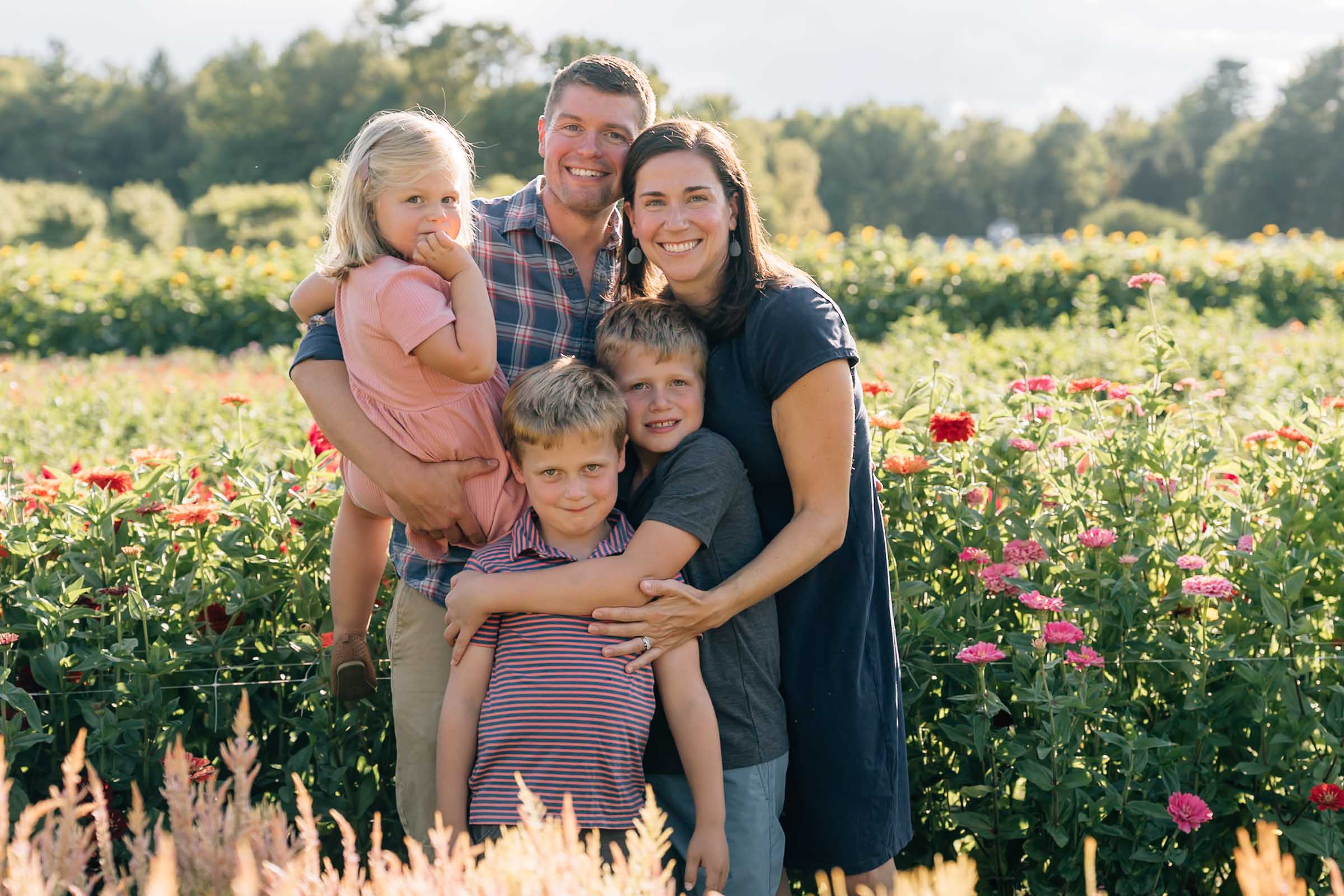 Family hugging in flower field at The Fells