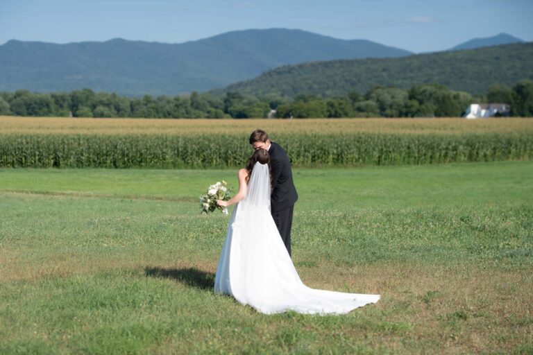Couple kissing in field after ceremony during Barn at Boyden Farm Summer Wedding