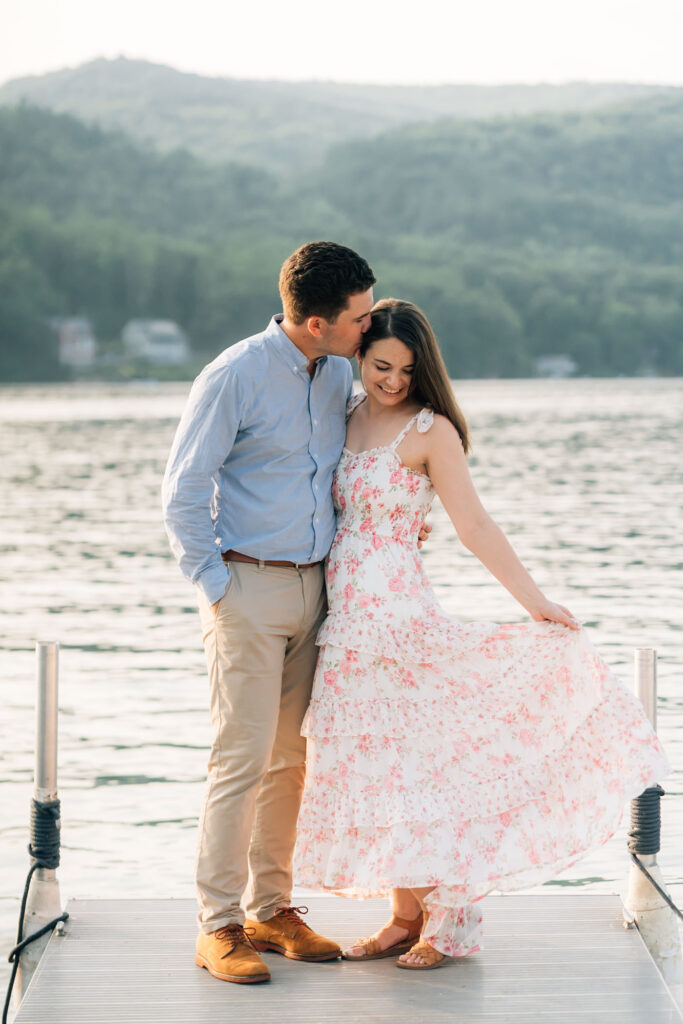 Couple standing on dock while woman swings dress