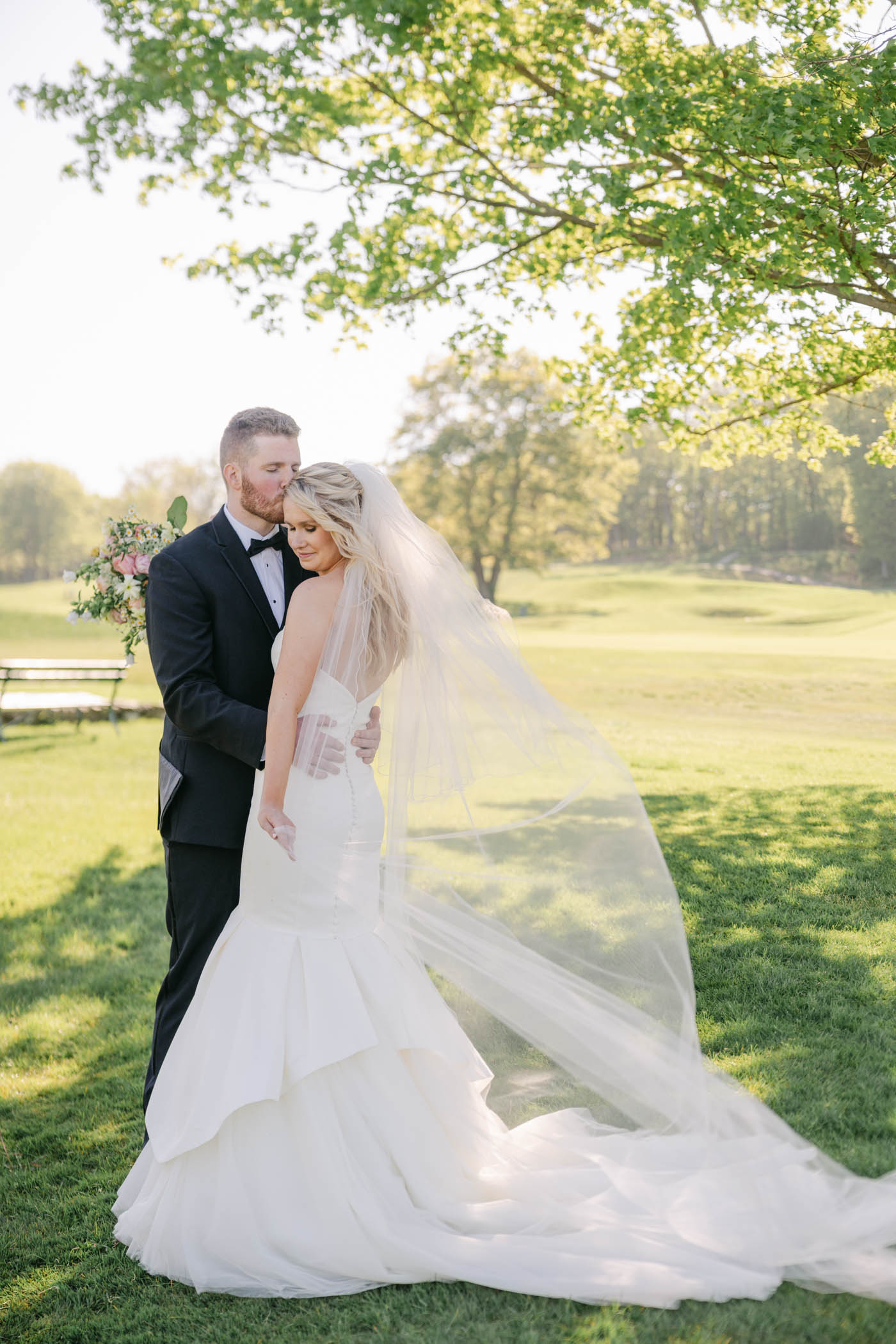 couple posing on golf course at massachusetts country club wedding