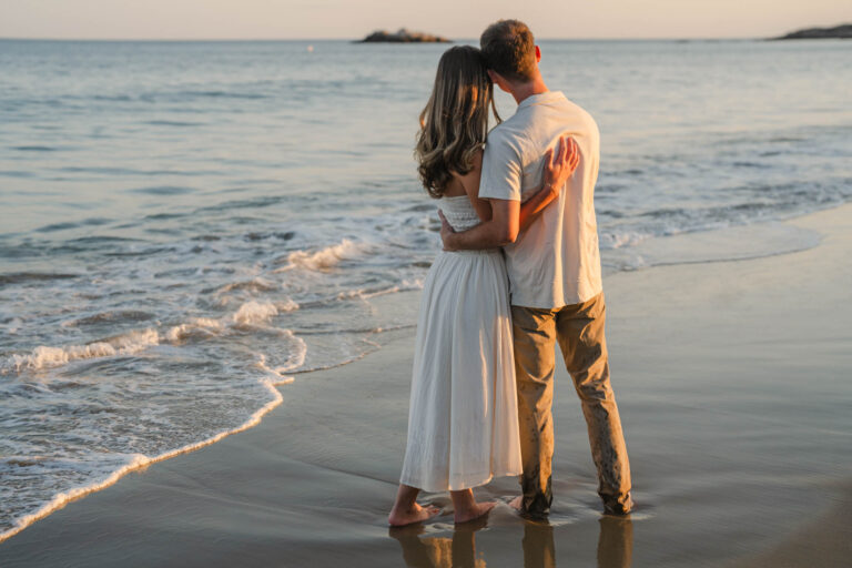 couple standing in the waves during Singing Beach engagement session