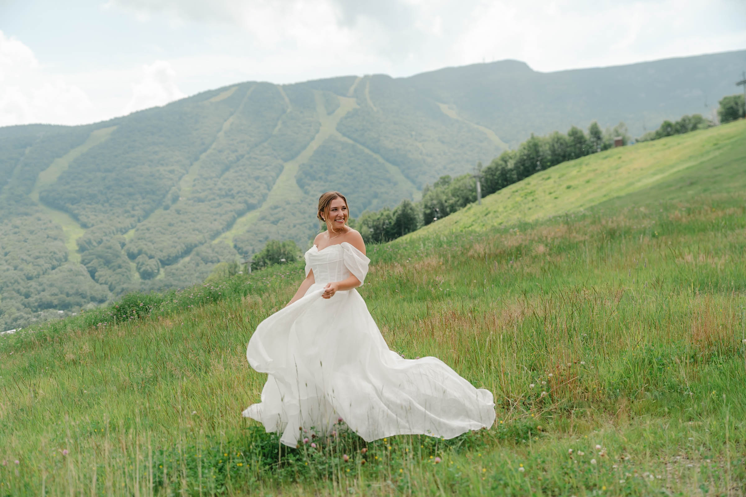 bride swishing dress at spruce peak wedding with views in background