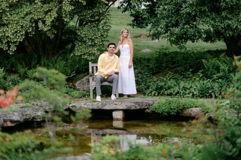 Couple pose by lily pond during stunning spring sunapee new hampshire engagement session at the fells