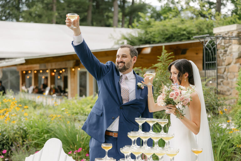 Couple toast on their way out of ceremony at The Wilburton, Manchester, VT
