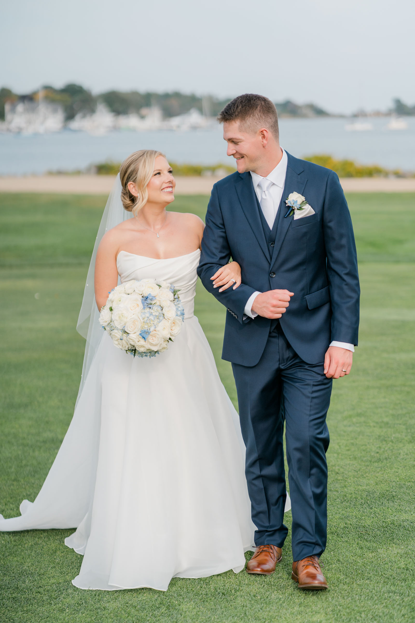 bridal portrait of couple walking with water behind them - wentworth by sea country club