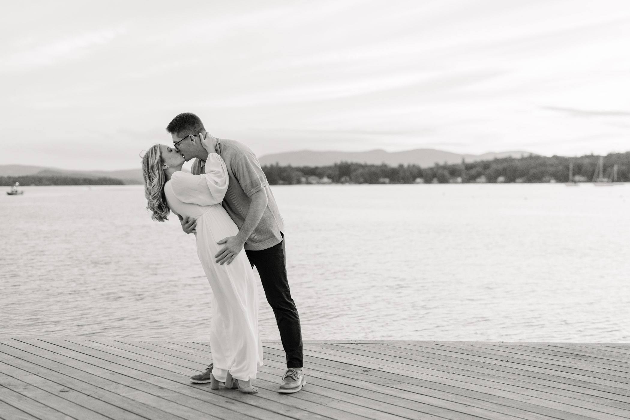 Couple sharing romantic dip and kiss on wolfeboro town docks, engagement session