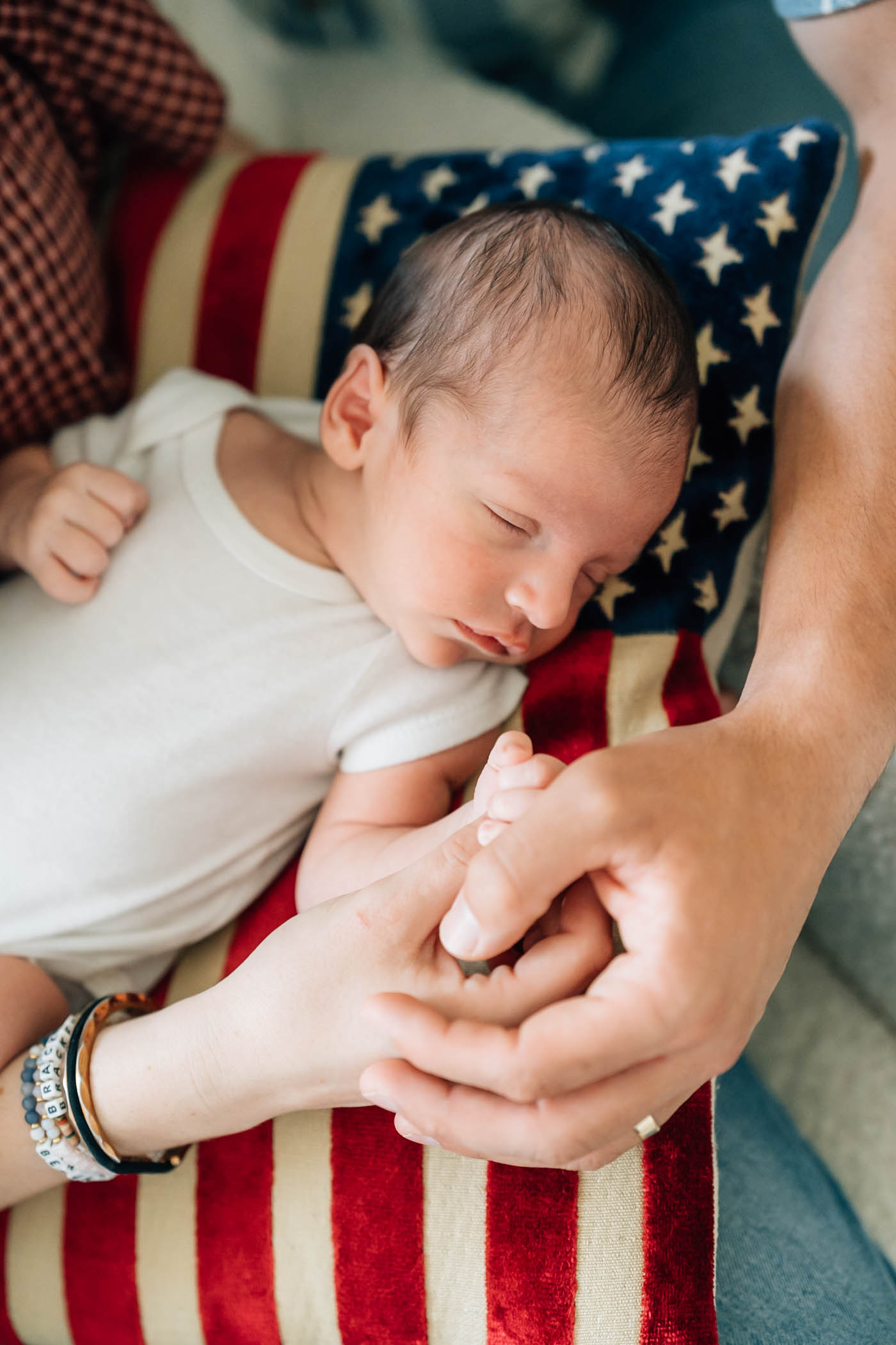 Baby lying on an american flag pillow during Hanover, NH newborn session