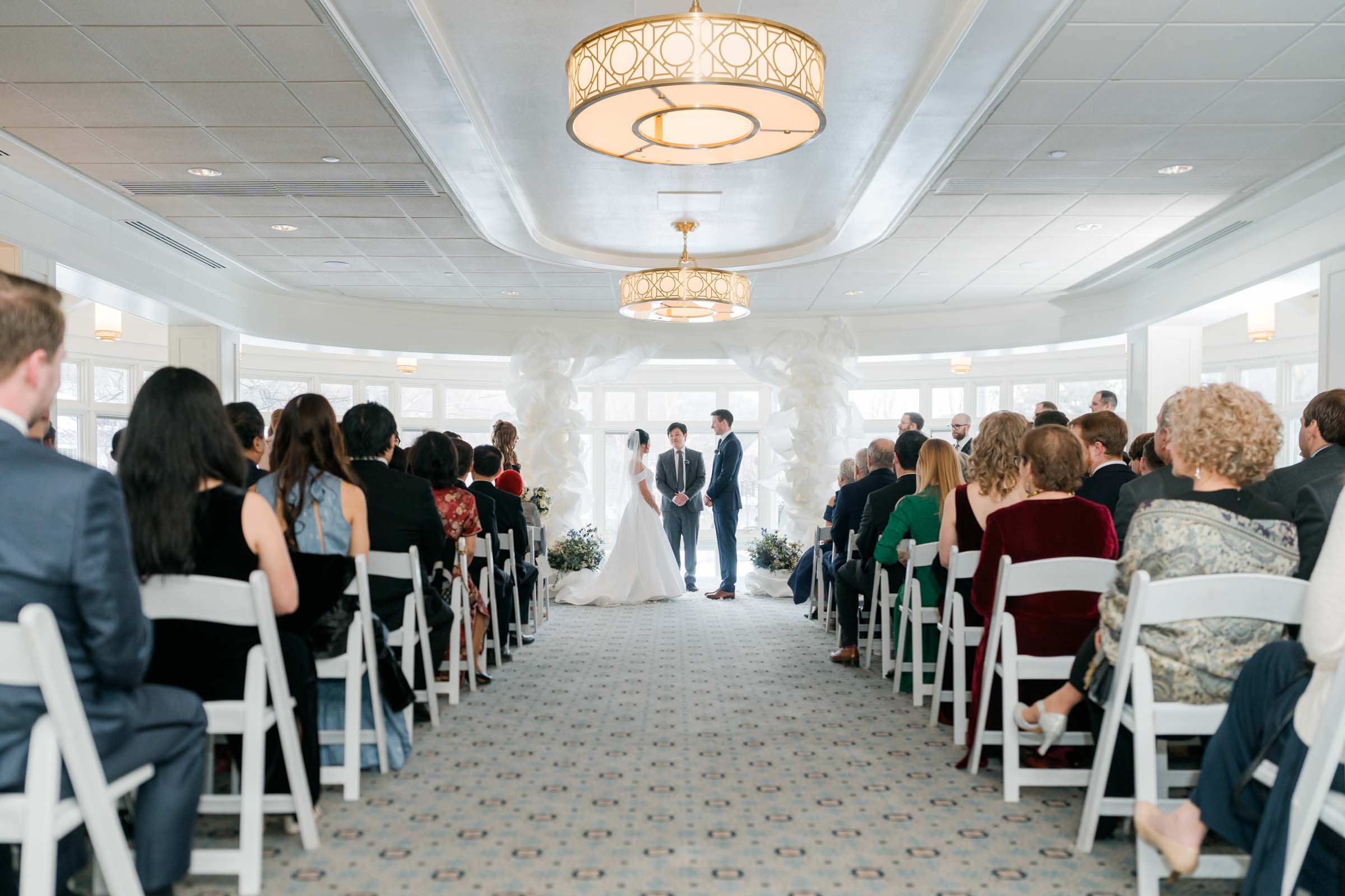 Woodstock Inn Winter Wedding - couple at top of aisle during ceremony in rockefeller ballroom
